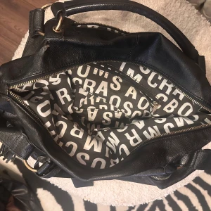 Väska Marc by Marc Jacobs  - Svart väska från Marc by Marc Jacobs, saknar en dragkedja på baksidan annars i fint skick. Haft i ca 10år och kan inte intyga äkthet då jag fått väskan därav lägre pris 