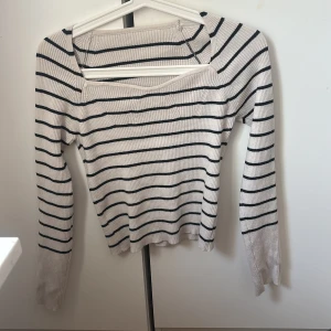 Randig ribbad tröja - Stretchig så att den passar ifrån S till XL. Säljer en stilren randig tröja med ribbad struktur. Tröjan har en fyrkantig halsringning och långa ärmar. Perfekt för en avslappnad look.