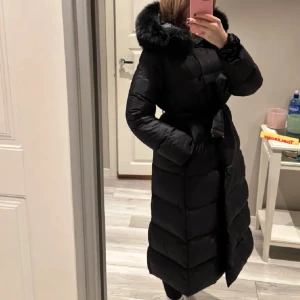 Svart dunjacka med pälskrage - Snygg och varm svart dunjacka med en fluffig pälskrage och knytbälte i midjan. Knappt använd 💗