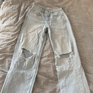 Fina jeans från Gina tricot  - Säljer ett par ljusa jeans från Gina tricot, slitningar på knäna. De har en klassisk femficksdesign och knappgylf. Ny pris 599 kr🩷