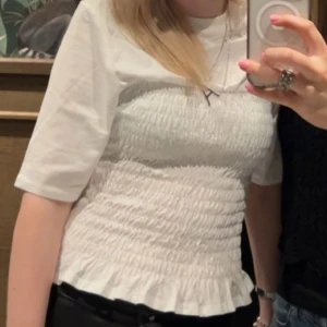 Vit smockad topp - Säljer en söt vit smockad topp med korta ärmar. Från H&M ☺️