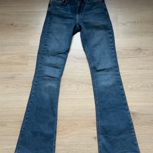 Blå bootcut jeans - Snygga blå bootcut jeans med klassisk design. Perfekta för en avslappnad stil. De har en bekväm passform och är tillverkade i ett slitstarkt material.