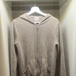 Beige cashmere hoodie från John Henric - Säljer en lyxig beige hoodie i kashmir från John Henric. Tröjan har en dragkedja framtill och en bekväm huva. Perfekt för en stilren och mysig look. original pris 2500kr. skickar inom 2 dagar 