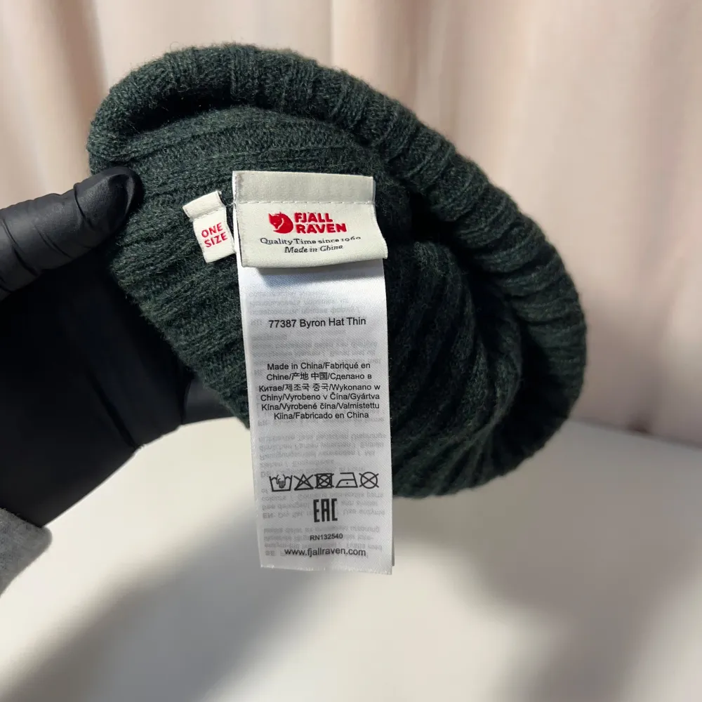 Säljer en stilren grön ribbad mössa från Fjällräven. Mössan har en enkel design med en liten etikett framtill. Perfekt för att hålla värmen under kyliga dagar.. Asusteet.