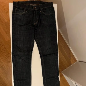Mörkblå jeans från Cheap Monday - Snygga mörkblå jeans från Cheap Monday med klassisk femficksdesign och dragkedja. Tillverkade i en bomullsblandning med lite stretch för extra komfort. Perfekta för en stilren look. 33/32