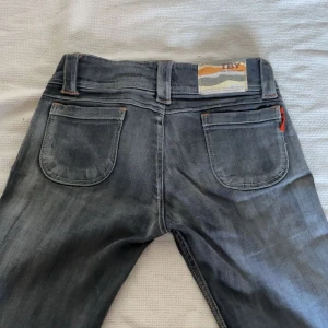 Grå jeansbyxor från Toxik - - Gråa lågmidjade jeans från TBY - Mått 📐 Midja tvärsöver 38cm, inneben 73cm och gren 17cm  - Fint skick  - Inga defekter utöver att de är uppsprättade längst ned  Skriv om ytligare funderingar tryck annars köp nu 💕