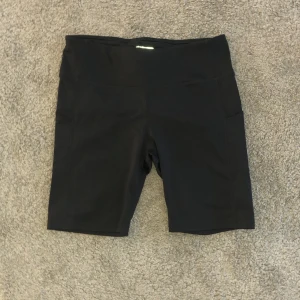 Svarta träningsshorts från Energetics - Snygga svarta träningsshorts från Energetics i storlek L. Perfekta för gymmet eller löprundan med en bekväm passform och elastiskt material. De har en hög midja för extra stöd och komfort. Shortsen är en blandning mellan cykelbyxor och vanliga shorts och har därför enligt mig en perfekt längd!! Säljer för att de är för stora för mig🥺❤️