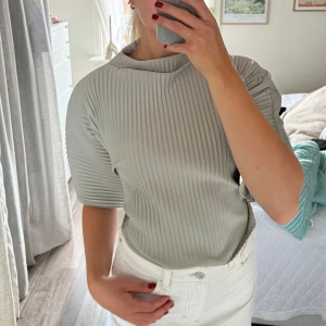 Ribbad blus  - Ribbad blus från Gina i en fin grön färg, knyt och öppen i ryggen. Helt ny 