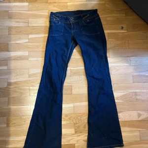 Snygga lågmidjade jeans! - Jättefina mörkblå lågmidjade jeans, som jag köpt second hand och enbart använt en gång! Fina unika fickor både där fram och bak, men tyvärr så fattas en knapp på ena fickan men påverkar inte användningen 