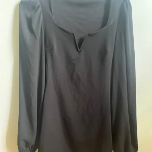 Svart klänning - Svart klänning från Nelly strl S. I fint skick, har två små fläckar (se bild). Säljes då den är lite för liten. Har lite vaddering så går att ha både med & utan bh. 100% polyester.