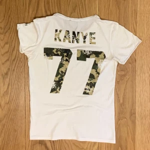 Concrete humanity vit t-shirt med tryck - Säljer denna snygga vita t-shirt med trycket KANYE 77 på ryggen. Skick 8/10. Små deofläckar som nästan inte syns som enkelt går att tvätta bort. Storlek small