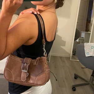 väska  - Super fin brun väska som passar perfekt till hösten! En liten men lagom handväska till en utekväll som klär upp en outfit perfekt. Väskan är från bikbok från några år tillbaka, den är i nyskick knappt använd🩷 skriv för fler frågor eller bilder🩷