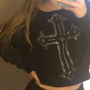 Svart topp - Svart tröja med kors av strass/rhinestones som passar allt från XS till M eller L. Mycket fint skick! (Ny annons med sänkt pris)