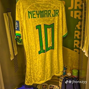 Gul fotbollströja med Neymar Jr - Säljer en gul fotbollströja med Neymar Jr's namn och nummer 10 på ryggen. Tröjan har gröna detaljer och är kortärmad. Perfekt för alla fotbollsfans som älskar Brasilien och Neymar Jr! Ja 