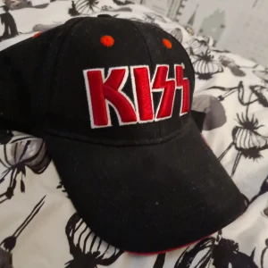 Kiss keps (rock merch) - Har förmodligen använt den bara en gång. Den har legat i garderoben i snart 3 år. Lite dammig men det går och borsta bort.  Hälften av pengarna går till välgörenhet
