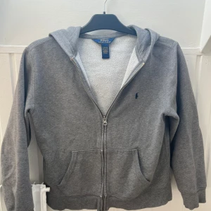 Grå polo hoddie - Tja! Säljer denna snygga hoddie för bra pris skicket är 7/10 och passar oldrar 14-16 (är large i barn storlek)