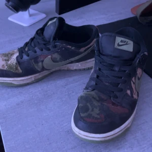 Nike dunk low camo - Säljer nu mina Nike dunks pga att de ej passar längre och har köpt nya, riktigt snygga och passar till allt. Storleken är 42,5 men passar 41,5 också. Skick 7/10 därför det billiga priset! Inga skador förutom att lite färg försvunnit från Nike loggan, se på bilden. Nypris går upp och ner hela tiden men de ligger just nu på 3000kr ungefär, men mitt pris är 450kr! Tveka inte med att höra av er, priset är ej hugget i Sten. Tvättas innan köp👌