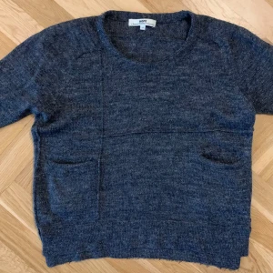 Mörkgrå stickad tröja från Hope - Säljer en mörkgrå stickad tröja från Hope. 60% ull, 20% linne, 8% alpacka, 12% akryl.