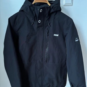 Svart skidjacka från Dope - Säljer en svart jacka från Dope med dragkedja och huva. Använd max 5 tillfällen. 