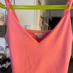 Rosa linnetopp från Amisu - Säljer en söt rosa linnetopp från Amisu. Toppen har smala axelband och en v-ringad design. Perfekt för varma sommardagar!