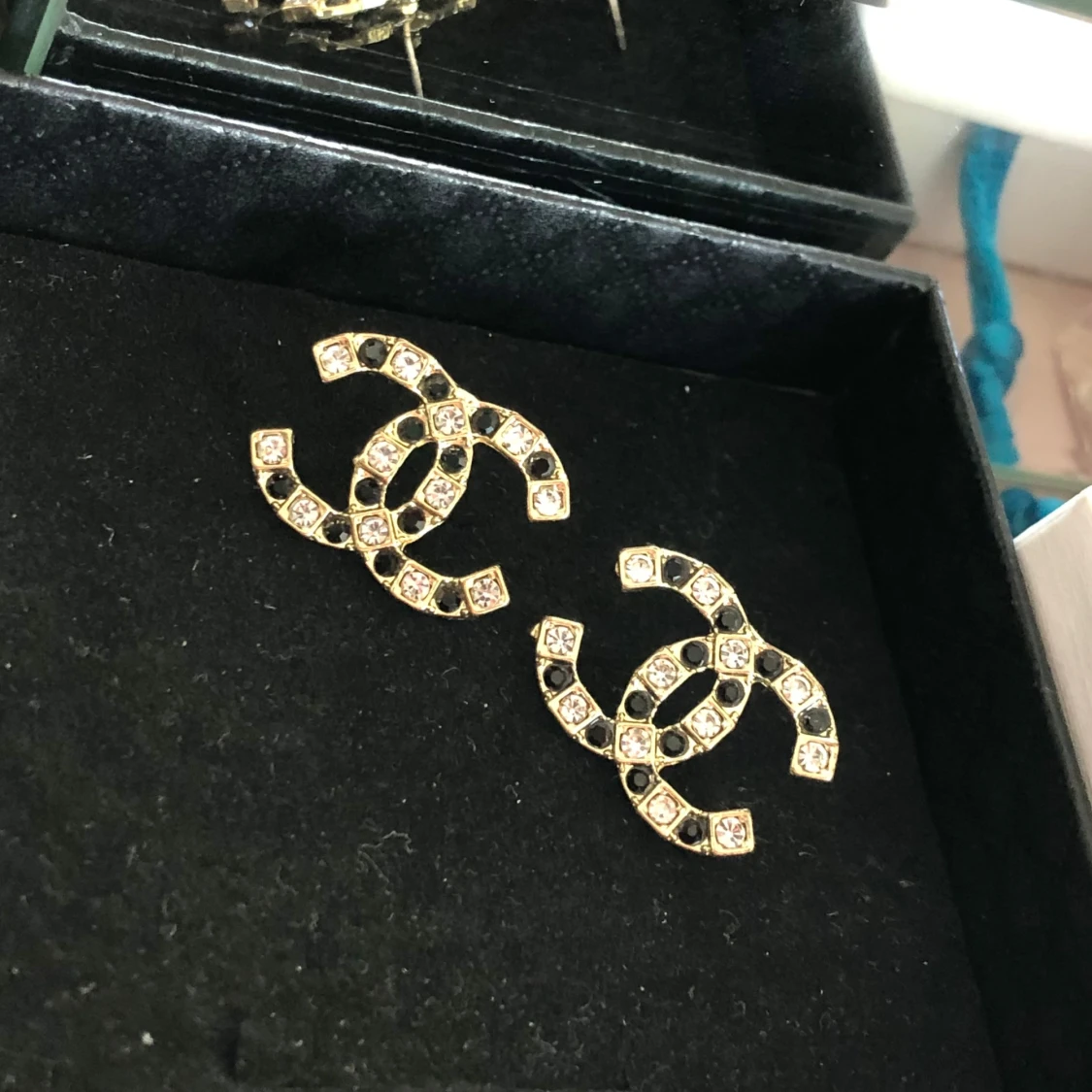 Guldiga örhängen med vit och svart kristall  - 90