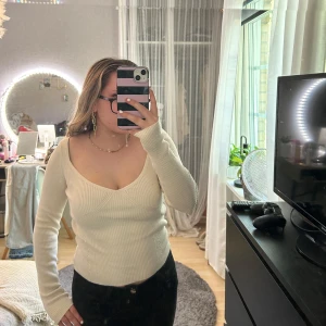 Vit tröja - Säljer en vit ribbad tröja som är  v-ringad. Tröjan har långa ärmar och en figurnära passform. Köpt från Gina Tricot och använd fåtal gånger