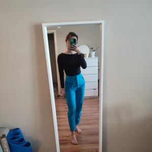 Turkosa byxor från Amisu - Snygga blåa byxor från Amisu med hög midja och en stilren design. Perfekta för att ge en färgklick till din outfit. Byxorna ger en väldigt fin passform och är tillverkade i ett bekvämt material.