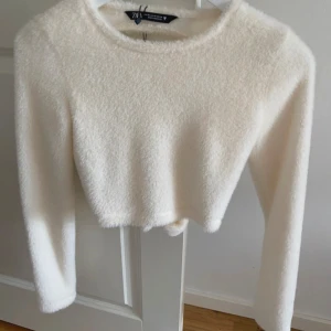 Vit stickad top - Superfin vit stickad croppad topp från Zara. Helt ny, prislappen sitter kvar. Säljer då den aldrig kommit till användning💕