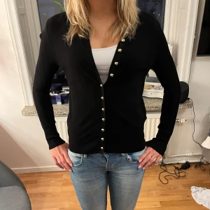 Svart kofta med guldknappar - Snygg svart kofta med guldknappar framtill. Jag har använt den max 5 gånger så den är väldigt ny! Skriv om ni har några frågor eller vill se fler bilder💗