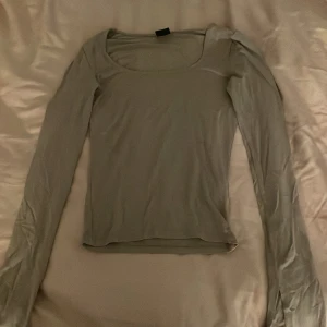 Beige långärmad topp från Gina Tricot - Säljer en stilren beige långärmad topp från Gina Tricot i storlek XS. Perfekt för lager-på-lager eller som den är. Toppen har en rund halsringning och är tillverkad i ett mjukt material.
