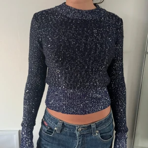 Glittrig mörkblå croppad tröja - Snygg mörkblå tröja med glittriga detaljer.