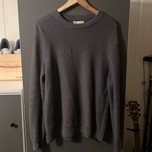 Grå stickad tröja från Zara - Säljer en stilren grå stickad tröja från Zara. Tröjan har en klassisk rund hals och långa ärmar med ribbade muddar. Perfekt för kyligare dagar och enkel att matcha med olika outfits.