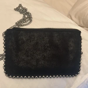 Svart axelväska med kedja - Snygg svart axelväska med kedjedetaljer och dragkedja. Nästan som ny❣️