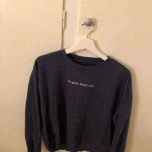 Mörkblå sweatshirt från 157 - Säljer en mörkblå sweatshirt från 157 med texten 'Live More, Worry Less' på bröstet. Tröjan har långa ärmar och en rund halsringning. Perfekt för en avslappnad stil.