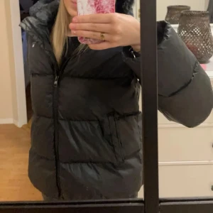 Svart dunjacka från GANT - Säljer en svart dunjacka från GANT med dragkedja och huva. Köpt på Kidsbrandstore för ca 4000kr
