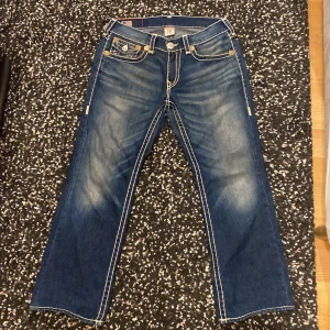 True Religion Jeans Ricky Super T - Ricky Super T, W34. Dom har blivit hemmed, annars bra skick. (Midja tvärsöver 45cm) (Ytterbenslängd 100cm) (Innerbenslängd 67cm) (Benöppning 23,5 cm)