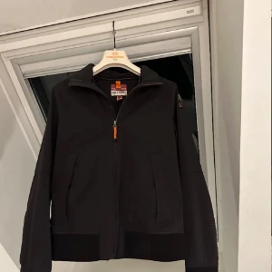 Svart jacka från Parajumpers - Snygg svart jacka från Parajumpers med dragkedja och huva. Inga defekter, vattentät, nypris: 3300kr! Jackan har en stilren design med två fickor framtill.