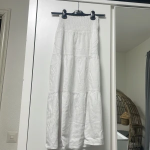 Lång vit kjol - oanvänd - Jättefin lång vit kjol, säljer för att det inte går att returnera. Den är jätteskön och bekväm pga ”A-slits” modellen. Köpt för 299kr, säljer för 149kr. Priset går att diskutera🤍