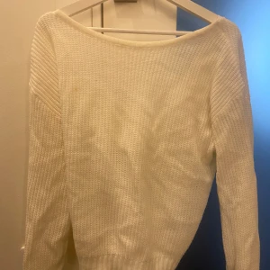 Vit stickad tröja med omlott-detalj - Säljer en superfin vit stickad tröja i storlek M. Den har en snygg omlott-detalj på baksidan och långa ärmar. Perfekt för höst och vinter, och den är både mysig och stilren. Passar bra till både jeans och kjol. 💫