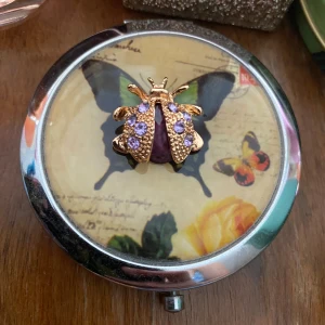 Söt brosch  - Söt liten nyckelpiga med lila stenar och i guldfärg. Okänt material och märke, helt ny.