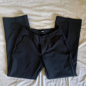 Bikbok Vera petite kostymbyxor med låg midja - Säljer ett par nya kostymbyxor då det inte passa och jag har köpt andra par. Kostymbyxorna är lågmidjade och modell petite så byxorna är kortare än vanligt. Nypris 500kr helt nya därför priset, skriv om ni har frågor annars använd köp nu! 