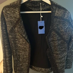 Svart och vit stickad jacka från Ann Taylor - Säljer en snygg svart och vit stickad jacka från Ann Taylor. Jackan är i storlek S och har en normal passform. Den är långärmad och perfekt för höst och vår. Materialet är mjukt och bekvämt, vilket gör den idealisk för både vardag och fest. Köp direkt eller ge prisförslag 💛