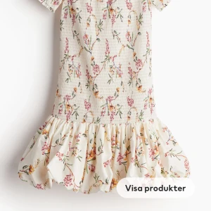 Blommig offshoulder klänning - Säljer en superfin blommig offshoulder klänning med volangdetaljer. Klänningen är i en ljus färg med ett vackert blommönster i rosa och grönt. Den är perfekt för sommarens alla fester och midsommarfiranden. Klänningen är i nyskick och har en tight passning som framhäver figuren. Materialet känns mjukt och skönt mot huden.