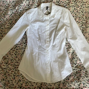 Figursydd Skjorta - Jätte fin figursydd skjorta som aldrig har använts.   Öppen rygg med rosett där bak.