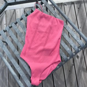 Rosa ribbad baddräkt - Superfin one shoulder baddräkt från Weekday använd ett fåtal gånger! Storlek XS.