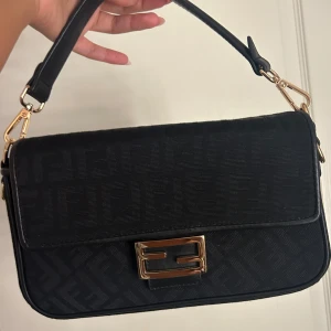 Ej äkta Fendi väska - Aldrig använd, bra kvalite, följer med ett tjockt band så man kan ha den crossbody