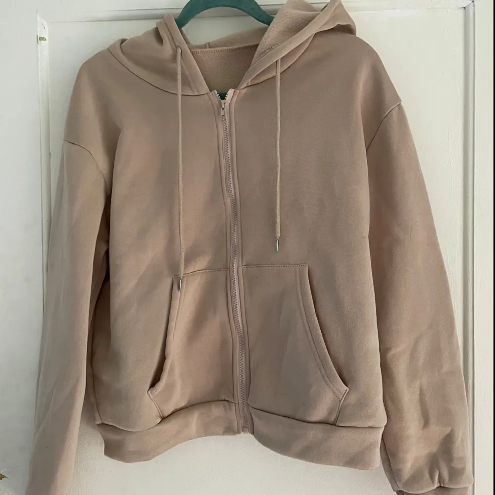 Säljer en mysig beige hoodie från Shein i storlek M. Den har en dragkedja framtill, två fickor och en huva med dragsnören. Perfekt för höst och vinter! 🧥. Tröjor & Koftor.