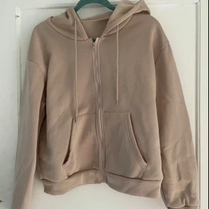 Beige hoodie från Shein - Säljer en mysig beige hoodie från Shein i storlek M. Den har en dragkedja framtill, två fickor och en huva med dragsnören. Perfekt för höst och vinter! 🧥