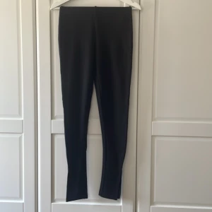 Tights från NaKD i strl XS - Tight med slits från NaKD, strl XS. Fint skick, ej blekta. Slits i nederkant av benen.