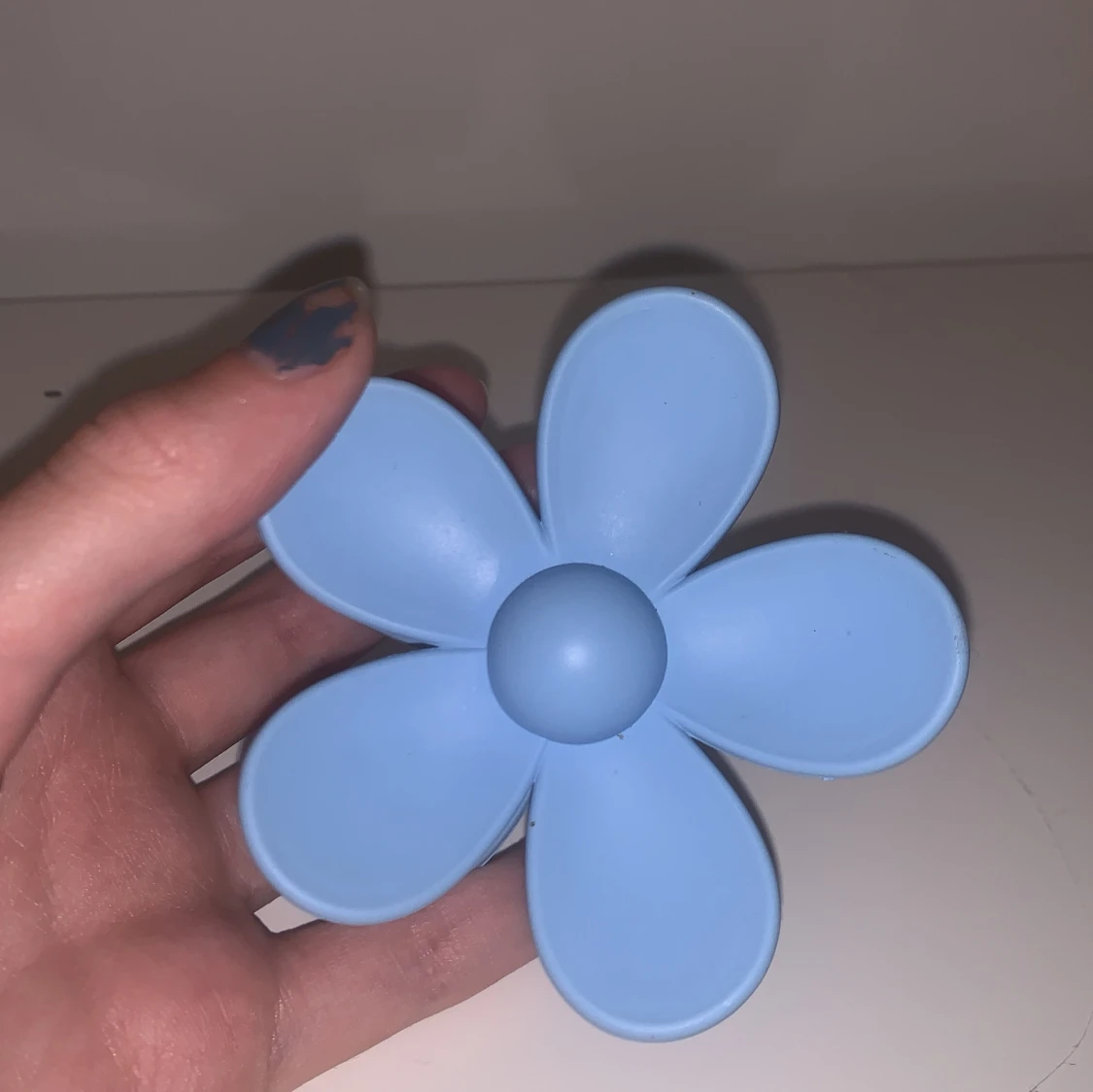 Blå hårklämma i form av en blomma